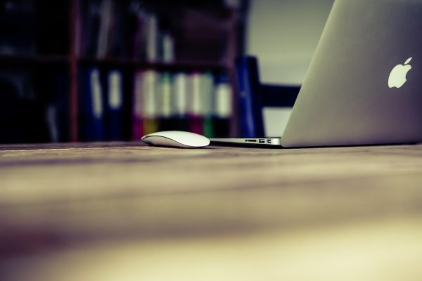 主编陈默在深色办公室内审阅检索教程稿件，桌面摆放着标注密集的打印稿与一杯咖啡，屏幕蓝光映在侧脸
